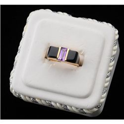 One unique designed ladies ring in 14k yellow  gold set with custom cut onyx with a  amethyst center