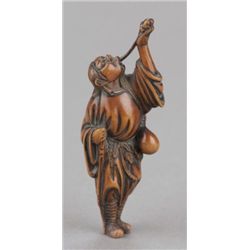 A tall wood netsuke of a Tekkai sennin.