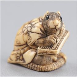 An ivory netsuke of a rat in gown.