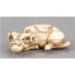 An ivory netsuke of a recumbent ox.