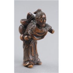 A wood netsuke of a bent over sennin.