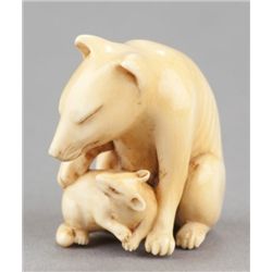 An ivory netsuke of a fox and her cub.
