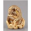 Image 3 : An ivory netsuke of a dragon emerging from an alms