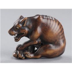 A wood netsuke of a yama-inu(wild dog).