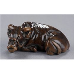 A wood netsuke of a recumbent ox.