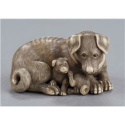 An ivory netsuke of a bitch and pup.