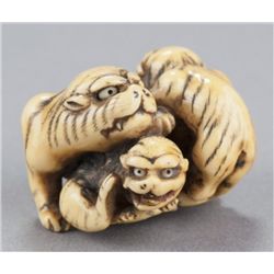 A ivory netsuke of a tigress and two cubs.