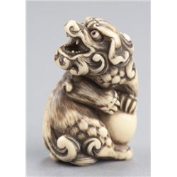 An ivory netsuke of a Shishi.