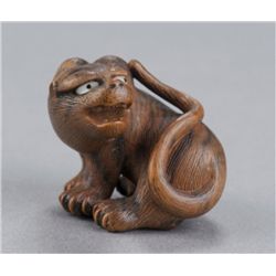 A wood netsuke of a tiger.