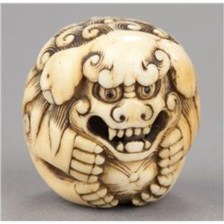 An ivory netsuke of a Shishi.