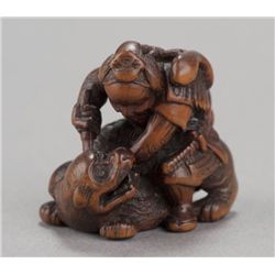 A carved boxwood netsuke of Ii no Hayata slaying t