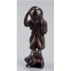 A tall wood netsuke of an octopus and monkey.