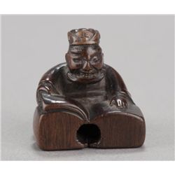A wood netsuke of Emma-O reading book.