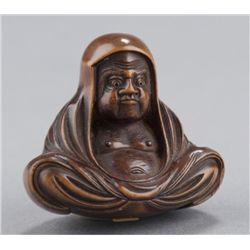 A wood netsuke of Daruma.