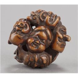 A wood ryusa netsuke of group of nine Noh masks.