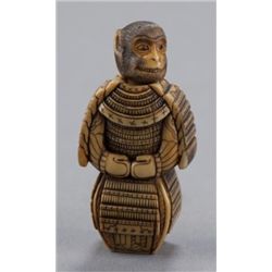An ivory netsuke of a monkey in a suit of armor.