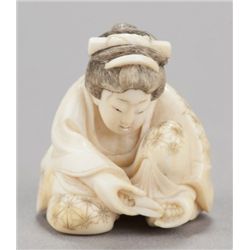 An ivory shunga netsuke of a woman cutting her toe