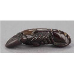 A lacquered wood and pottery netsuke of a lobster.