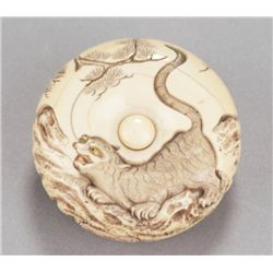 An ivory manju of a tiger on a rock.