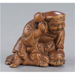 A wood netsuke of Daikoku.