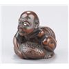 Image 1 : A wood netsuke of a blind man lifting scrotum.