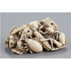 An ivory netsuke of a toad with insects.
