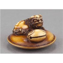An Asakusa school ivory netsuke of a Fu lion.