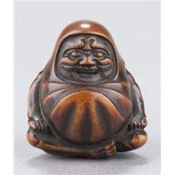 A wood netsuke of Daruma.