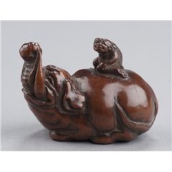 A wood netsuke of a baku and monkey.