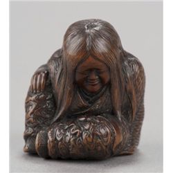 A wood netsuke of Shojo sleeping.