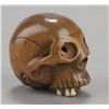 Image 1 : A wood netsuke of a skull with ivory teeth.