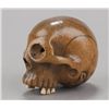 Image 2 : A wood netsuke of a skull with ivory teeth.