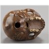 Image 6 : A wood netsuke of a skull with ivory teeth.