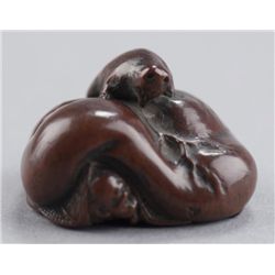 A wood netsuke of a tanuki