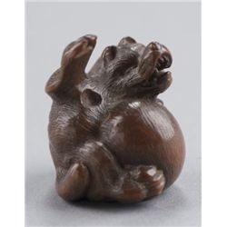 A wood netsuke of a tanuki.
