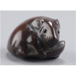 A wood netsuke of a rat on lima bean.
