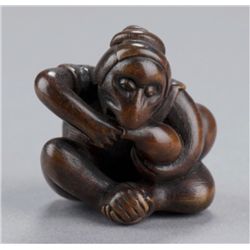 A wood netsuke of a monkey.
