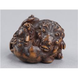 A wood netsuke of a shishi group.