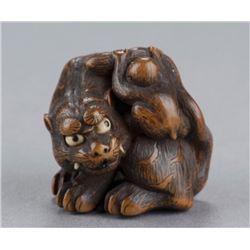 A boxwood netsuke of a tiger and monkey.