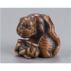 A wood netsuke of a tigress and cub.
