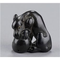 A kaki wood netsuke of a wolf.