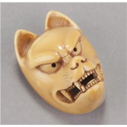 An ivory netsuke of a Kitsune mask.