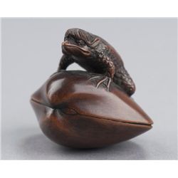 A wood netsuke of a kappa on clam.