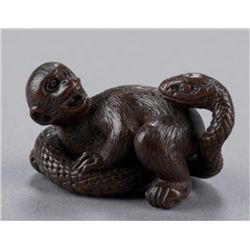 A wood netsuke of a monkey and snake.