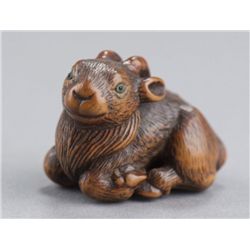 A wood netsuke of a goat.