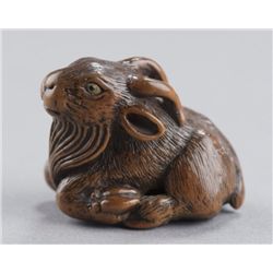 A wood netsuke of a goat.