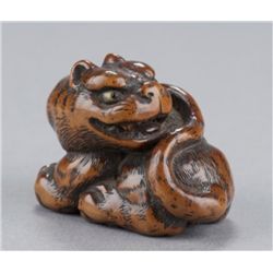 A wood netsuke of a tiger.