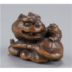A wood netsuke of a tiger and cub.
