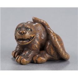 A wood netsuke of a tigress.