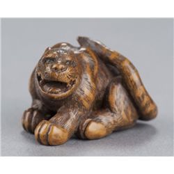 A wood netsuke of a tigress.